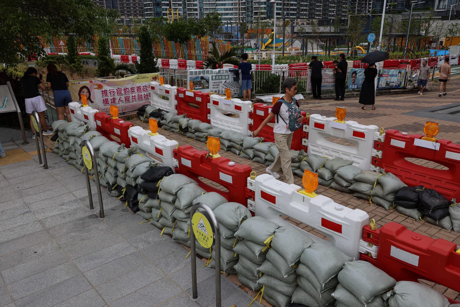 居民走过为防止超强台风桦加沙造成洪水而放置的沙袋 居民走过为防止超强台风桦加沙造成洪水而放置的沙袋